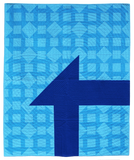 Minimalist Churn Dash quilt, showing light and medium blue churn dash blocks in the background of a large dark blue partial churn dash block.